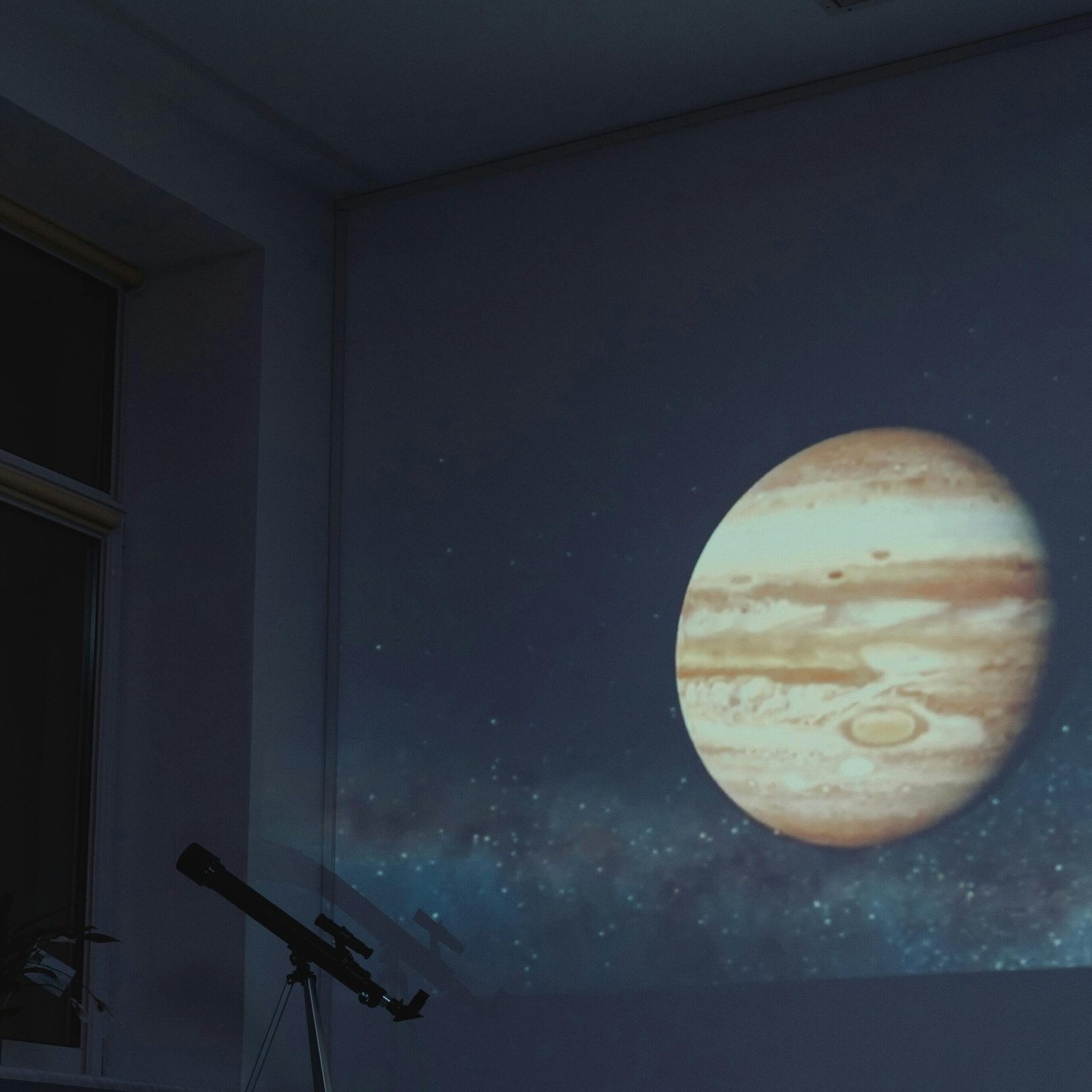 Students watch a projected image of Jupiter in a dark classroom setting, enhancing their astronomy learning.
