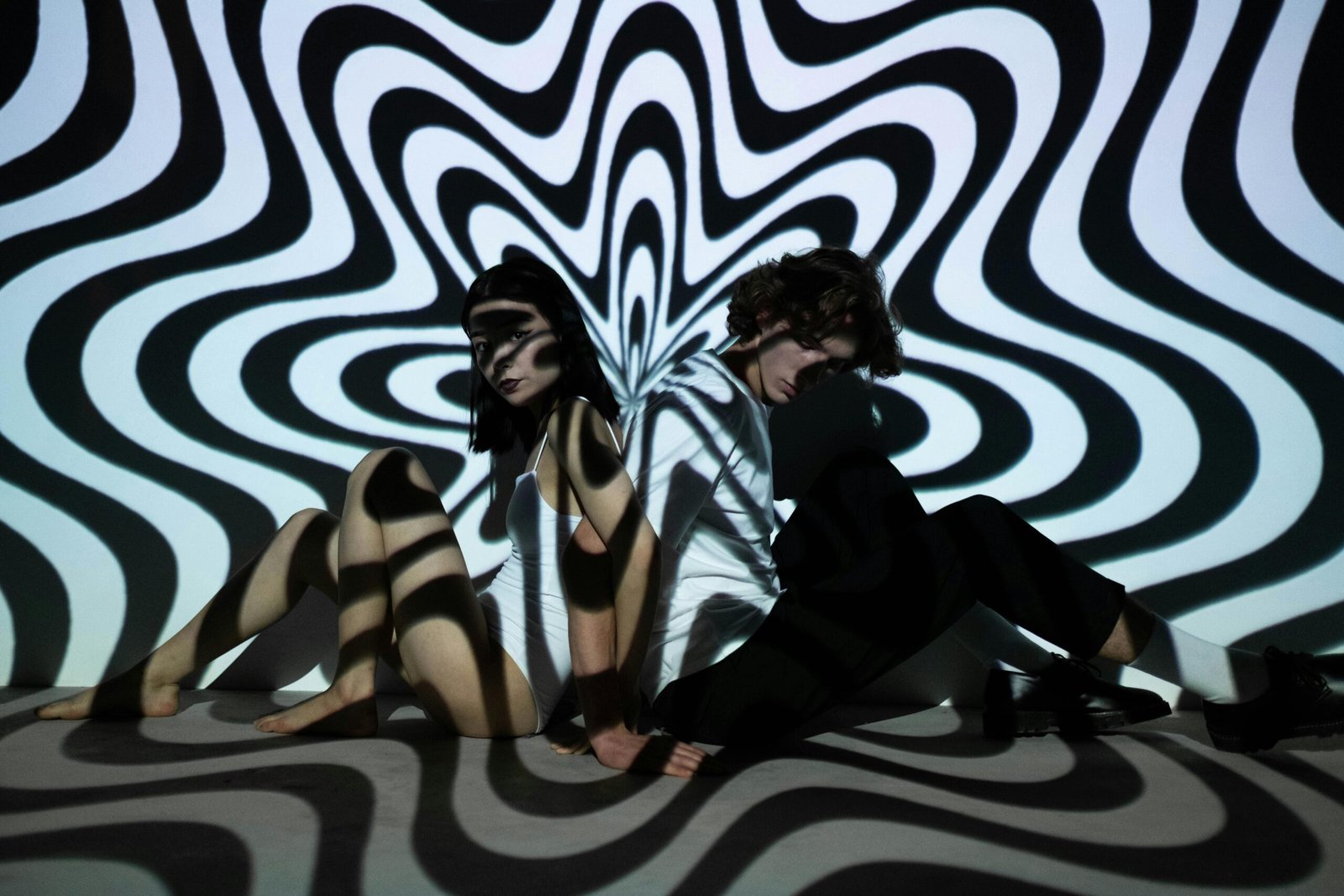 A vibrant double exposure featuring a man and woman with captivating optical illusions and abstract patterns.